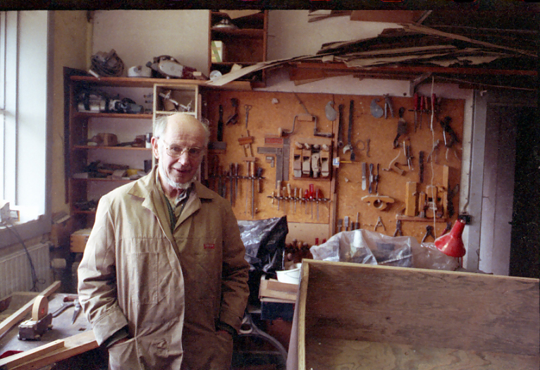 Ébéniste dans son atelier, mur d’outils à main