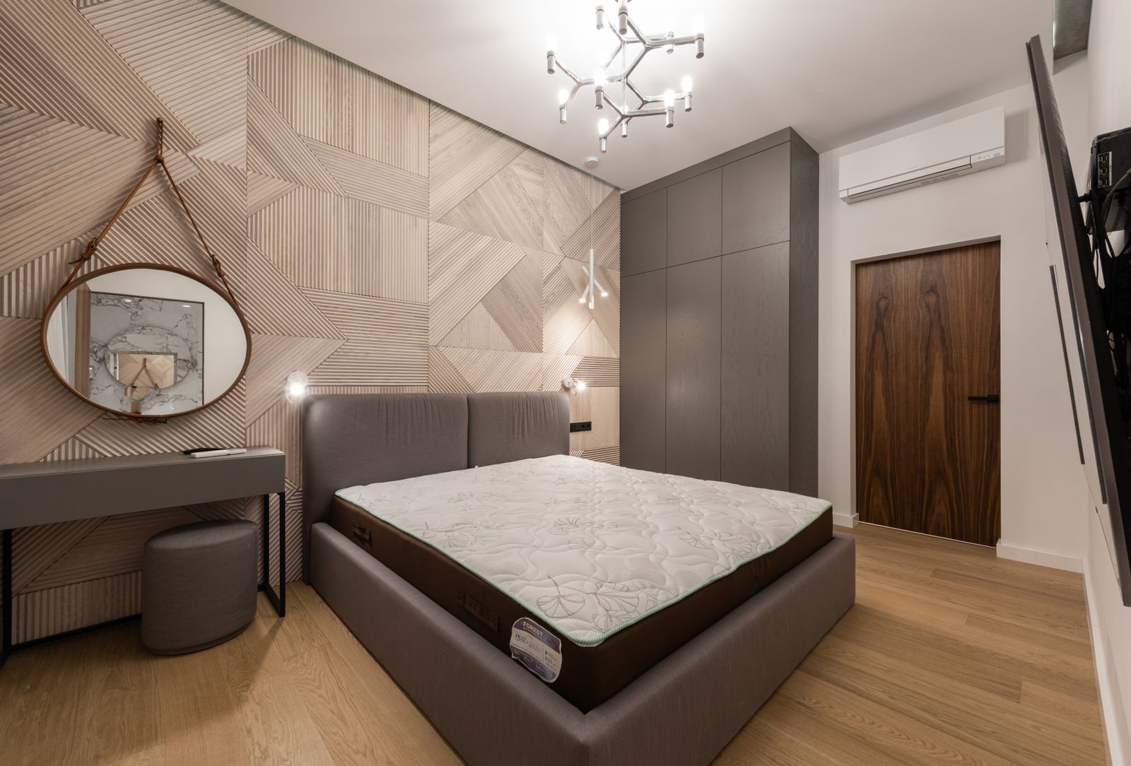 Chambre contemporaine, panneau bois géométrique et lit gris